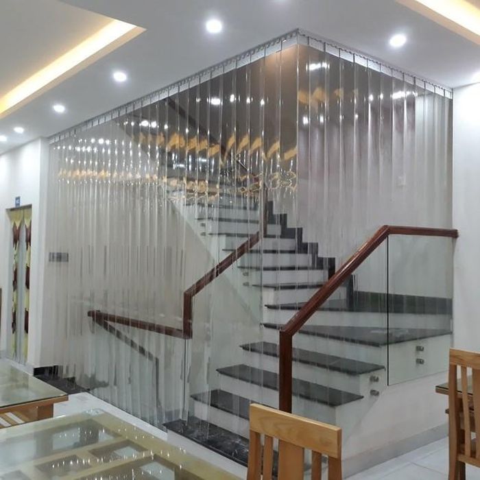 Nếu cầu thang quá gần cửa chính và không thể đặt vật chắn trực tiếp, treo rèm cửa dày ở cửa chính là một giải pháp thay thế.