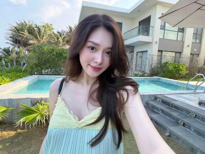 Tường San diện chiếc váy maxi hai dây màu xanh pastel với thiết kế suông nhẹ, kết hợp phong cách trang điểm trong trẻo và mái tóc buông tự nhiên. Khung cảnh ngập tràn cây xanh cùng hồ bơi càng tôn lên vẻ dịu dàng, thanh lịch của nàng Á hậu.