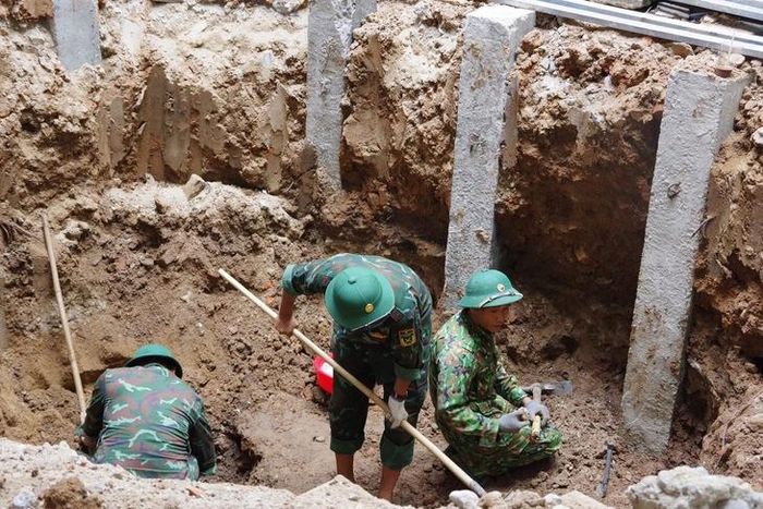 Lực lượng chức năng phát hiện và quy tập 4 hài cốt liệt sĩ tại khu vực đang thi công trong khuôn viên Bệnh viện Đa khoa khu vực Thạch Hãn. Ảnh: Xuân Diện.