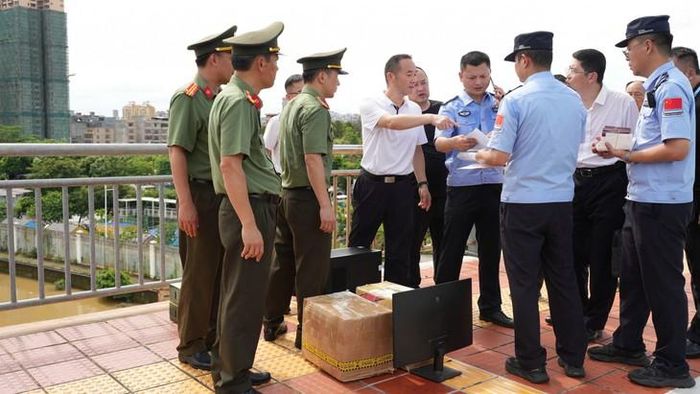 Bàn giao tài liệu, tang vật có liên quan cho phía công an Trung Quốc. Ảnh: Công an tỉnh Quảng Ninh