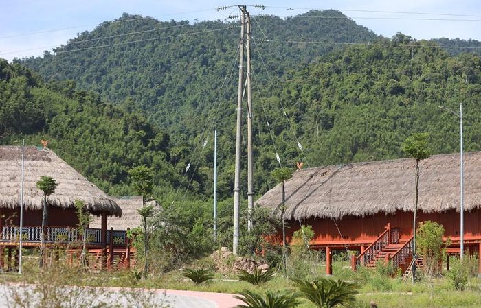 Cột điện đường dây 35kV "án ngữ" ngay trước nhà dài tại làng văn hóa dân tộc Cơ Tu. Ảnh: VT