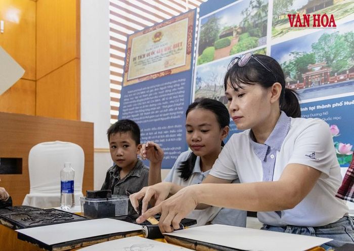 Cô giáo mỹ thuật Bùi Phượng hướng dẫn học sinh thực hành in tranh làng Sình