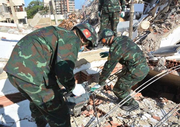 Lực lượng cứu hộ tìm kiếm nạn nhân trong đống đổ nát. Ảnh: TTXVN phát