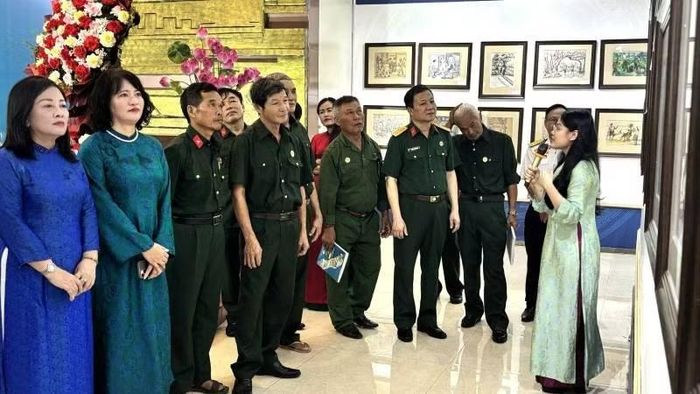 Các đại biểu và cựu chiến binh xem triển lãm tranh ký họa.