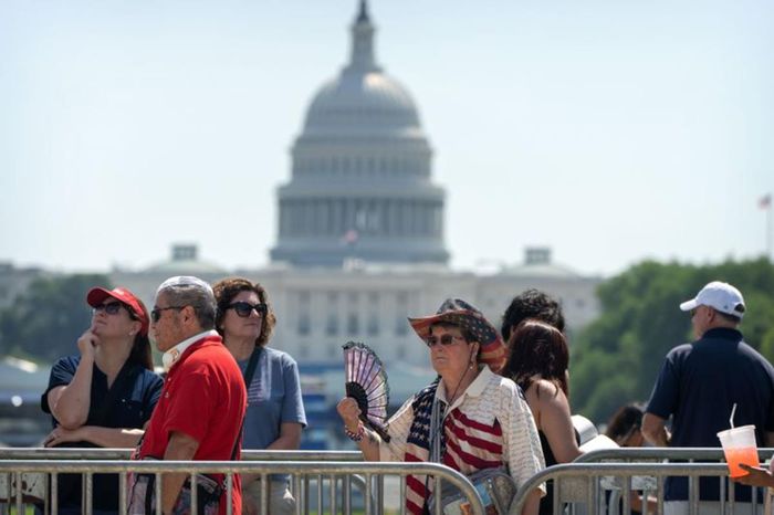 Người dân dùng quạt để giảm bớt cái nóng trong lúc xếp hàng tại khu vực National Mall (Mỹ) ngày 30-6. Ảnh: AP