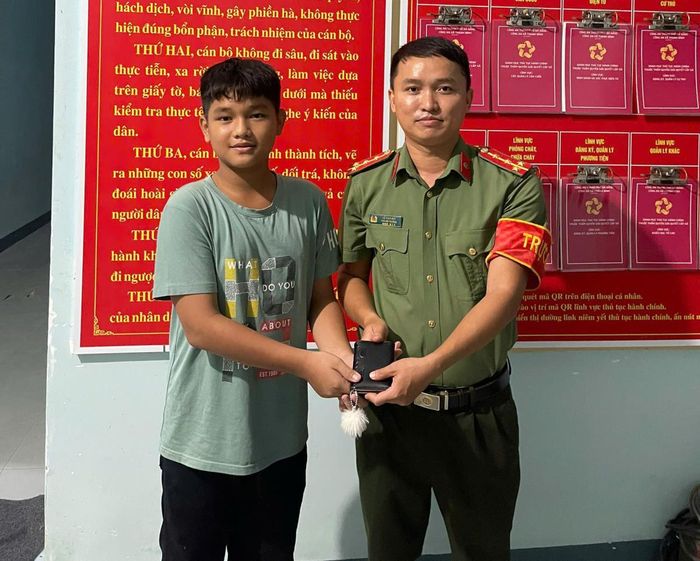 Em Điền giao nộp chiếc ví nhặt được cho Công an xã Thạnh Bình.