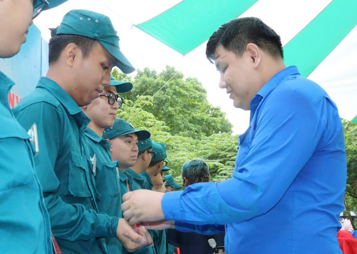 Bí thư Đoàn phường Xuân Hòa Lê Thanh Bình trao quyết định và huy hiệu đoàn đến đoàn viên mới. Ảnh: CẨM TUYẾT
