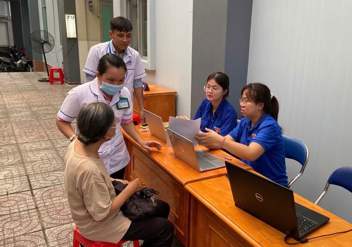 Đoàn viên, thanh niên phường Phú Thọ Hòa hỗ trợ công tác khám sức khỏe cho người lớn tuổi. Ảnh: CẨM TUYẾT