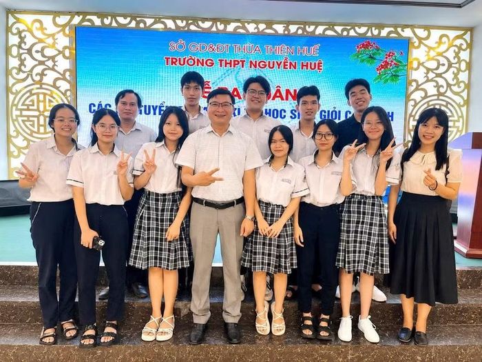 Hoàng Đức Huynh (hàng trên, thứ 2 từ phải qua) cùng Ban Giám hiệu nhà trường, các thầy cô giáo và Đội tuyển học sinh giỏi Vật lí tại Lễ ra quân tuyển học sinh giỏi lớp 12.