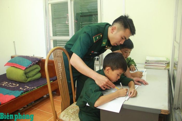 Cán bộ Đồn Biên phòng Chiềng On, Bộ đội Biên phòng tỉnh Sơn La hướng dẫn các con nuôi của đơn vị học tập. Ảnh: Đơn vị cung cấp