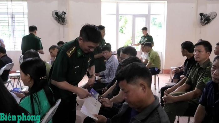 Cán bộ Bộ đội Biên phòng phát tờ rơi tuyên truyền pháp luật cho người dân. Ảnh: Trung Dũng