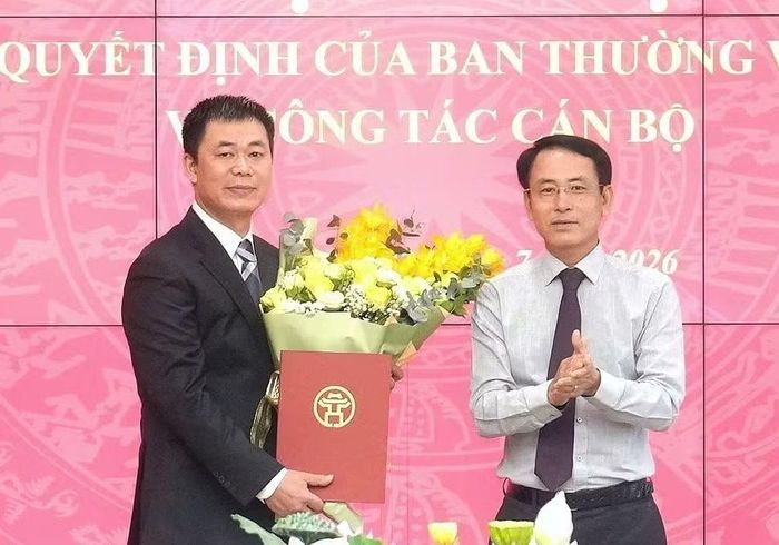 Phó Bí thư Thường trực Thành ủy Hà Nội Nguyễn Trọng Đông trao quyết định và tặng hoa chúc mừng ông Nguyễn Văn Toàn. Ảnh: HNM.