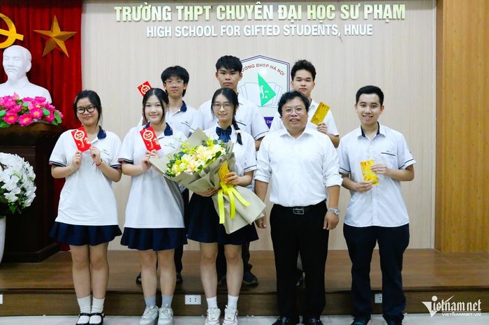 Thầy Trương Trọng Khánh tặng quà cho thủ khoa Hoàng Hương Giang (cầm hoa) và các học sinh lớp 12 Toán 1 đạt kết quả cao ở kỳ thi tốt nghiệp THPT năm 2026 và trong năm học vừa qua. Ảnh: Thanh Hùng