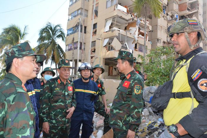  Đoàn Việt Nam trao đổi với lực lượng của địa phương tại hiện trường tìm kiếm. Ảnh: QĐND