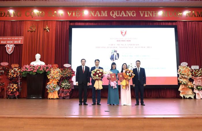 GS.TS. Nguyễn Vũ Quốc Huy, quyền Giám đốc Đại học Huế và GS.TS. Trần Đăng Hòa, Phó Giám đốc Đại học Huế trao quyết định và tặng hoa chúc mừng Ban Giám hiệu Trường Đại học Ngoại ngữ. Ảnh: Đại học Huế