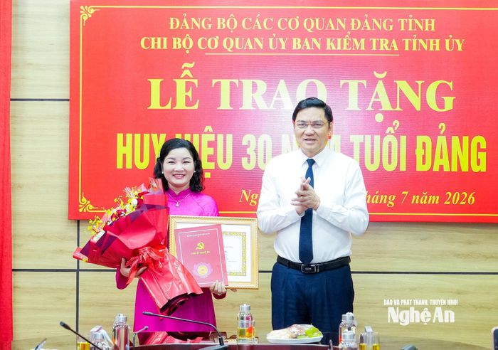 Phó Bí thư Thường trực Tỉnh ủy, Chủ tịch HĐND tỉnh Hoàng Nghĩa Hiếu tặng hoa chúc mừng đồng chí Nguyễn Thị Hồng Hoa - Ủy viên Ban Thường vụ, Chủ nhiệm Ủy ban Kiểm tra Tỉnh ủy. Ảnh: Phạm Bằng