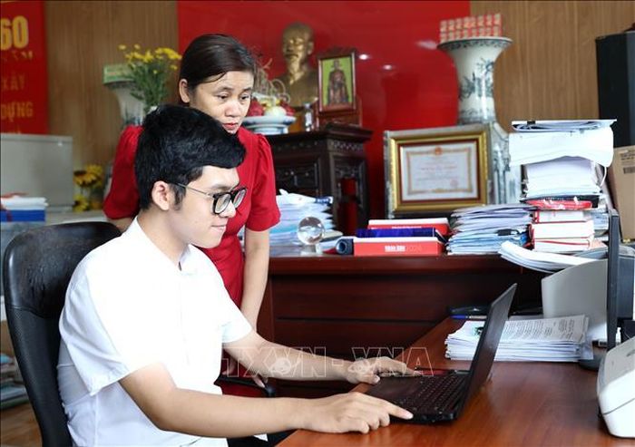 Hoàng Quang Minh và mẹ tra cứu điểm thi tốt nghiệp Trung học phổ thông năm 2026. Ảnh: Thế Duyệt/TTXVN