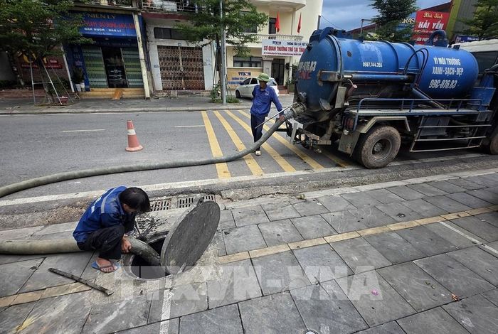 Công nhân Trung tâm Thoát nước và Xử lý nước thải tỉnh Bắc Ninh nạo vét cống ngầm tại phường Bắc Giang. Ảnh: Danh Lam – TTXVN 