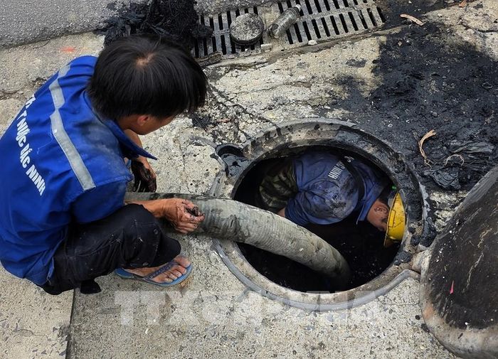 Công nhân Trung tâm Thoát nước và Xử lý nước thải tỉnh Bắc Ninh nạo vét cống ngầm trên tại phường Bắc Giang. Ảnh: Danh Lam – TTXVN 