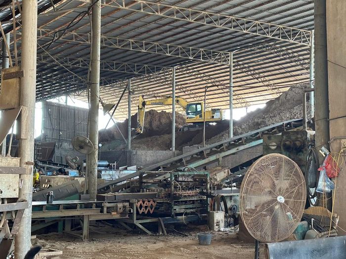 Máy xúc hoạt động tại khu vực cấp nguyên liệu.