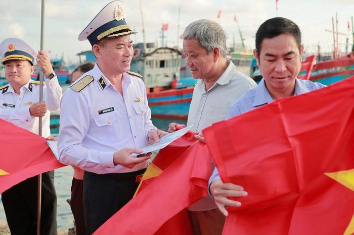 Chuẩn Đô đốc Nguyễn Đăng Tiến tặng quà, phát tờ rơi cho ngư dân đặc khu Lý Sơn, tỉnh Quảng Ngãi. Ảnh: Ngọc Vĩnh