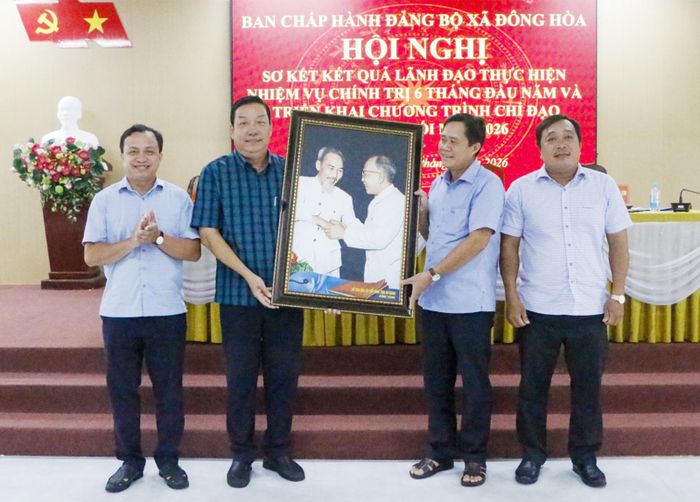 Phó Giám đốc Sở Văn hóa và Thể thao tỉnh An Giang Nguyễn Văn Mao (thứ hai, từ trái qua) tặng bức tranh lưu niệm cho Ban Chấp hành Đảng bộ xã Đông Hòa.