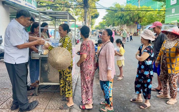 Trao bánh mì và nước uống miễn phí cho người dân.