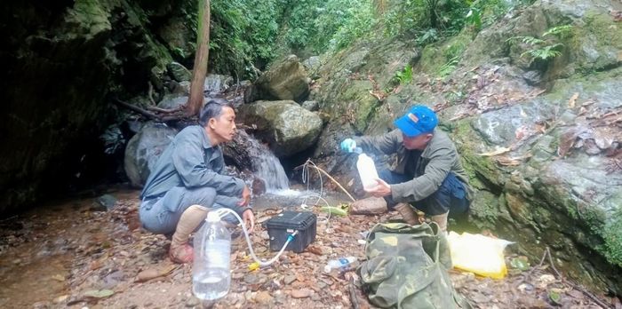 Ông Trần Hữu Vỹ (bên trái), Giám đốc Trung tâm GreenViet lấy mẫu nước để nghiên cứu Sao la theo công nghệ eDNA.
