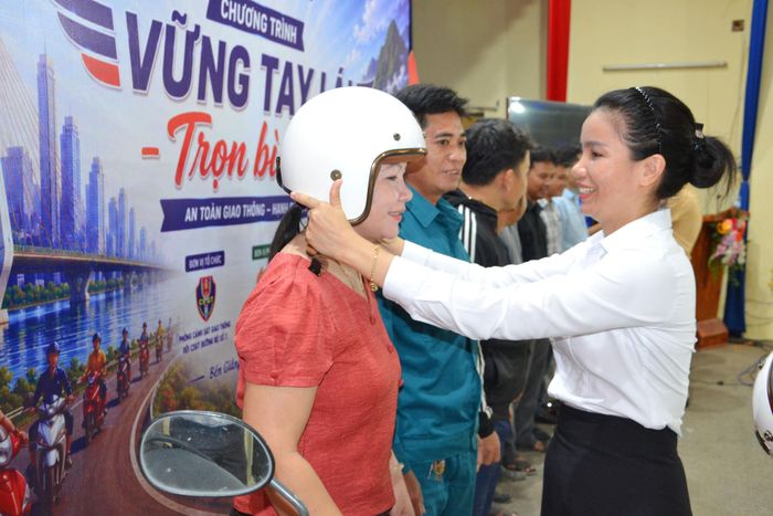 Bà Hiền Thị Kim Hương, Phó Chủ tịch UBND xã Bến Giằng tặng mũ bảo hiểm cho đại diện các thôn trên địa bàn xã. Ảnh: CÔNG TÚ