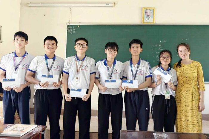 Hoàng Lê Minh Đức (bìa trái) cùng các bạn nhận thưởng từ cô giáo chủ nhiệm Nguyễn Thị Thu Thủy. Ảnh: NVCC