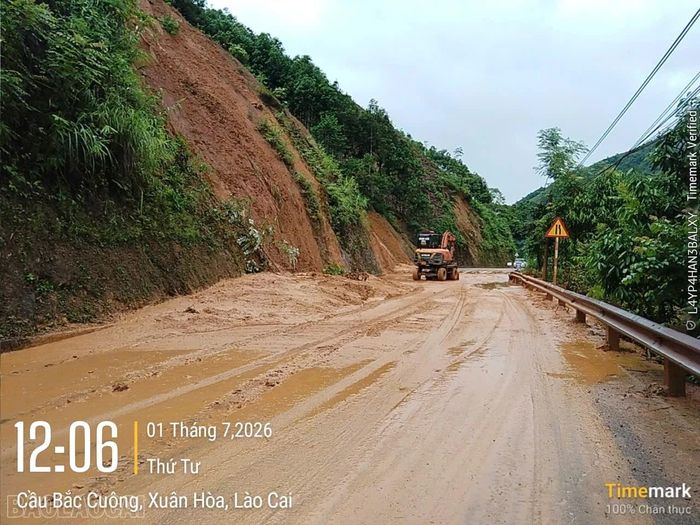 Máy móc được huy động hót dọn đất đá, bảo đảm giao thông bước đầu tại khu vực sạt lở.