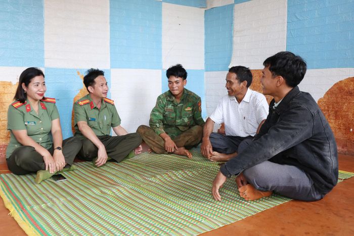 Anh Điểu Nguyên (bên phải) cùng Công an xã Quảng Trực gặp gỡ, tuyên truyền các tín đồ chấp hành các quy định về quản lý, bảo vệ biên giới