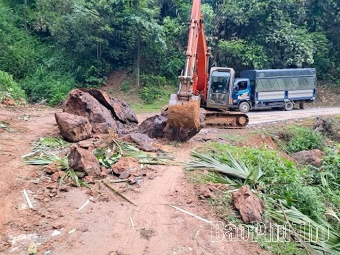 Lực lượng chức năng đã huy động máy móc khẩn trương thu dọn đất đá.