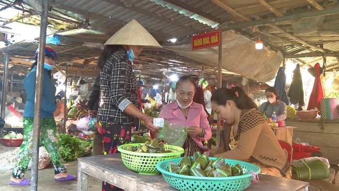 Người dân làng Đại Hào bán bánh ít lá gai ở chợ Thuận - Ảnh: N.D