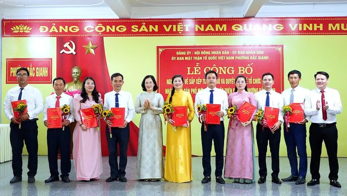 Các đồng chí lãnh đạo phường Bắc Gianh trao quyết định và chúc mừng đội ngũ cán bộ các tổ dân phố mới sau sáp nhập, kiện toàn - ẢNh: N.M