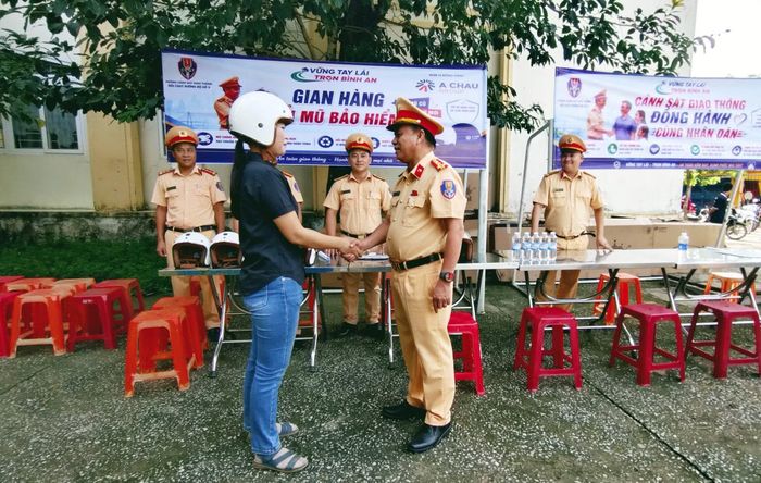 Đại tá Phan Thanh Hồng, Trưởng phòng CSGT Công an TP Đà Nẵng, tặng mũ bảo hiểm đạt chuẩn và trực tiếp tuyên truyền an toàn giao thông cho người dân.