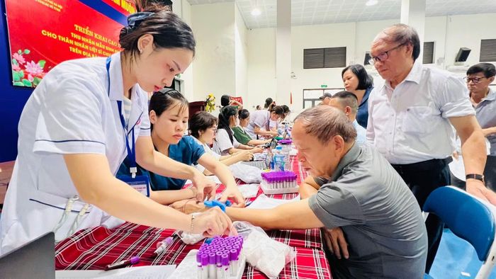 Nhân viên y tế lấy mẫu sinh phẩm ADN thân nhân các liệt sĩ chưa xác định được thông tin tại Nhà đa năng Trường THCS Thành Công vào sáng nay.