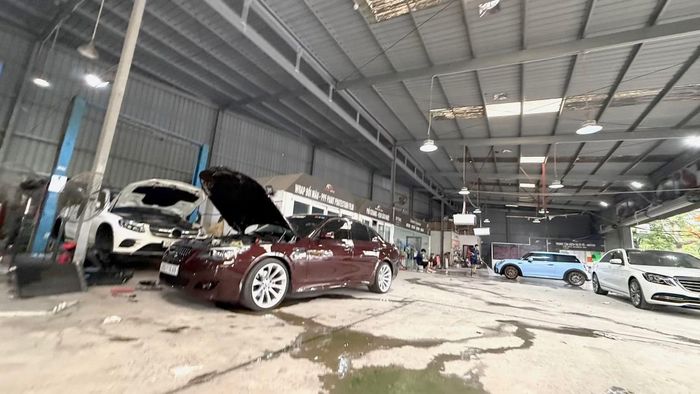 Nước làm mát của một xe ô tô đang sửa tại An Đức Auto - Service &amp; Spa cũng vương vãi khắp sàn garage.