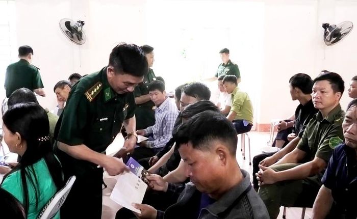 Bộ đội Biên phòng Lào Cai phát tờ rơi tuyên truyền pháp luật cho người dân xã Pha Long. Ảnh: Trung Dũng