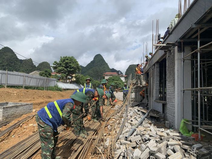 Cán bộ, chiến sĩ Trung đoàn 2, Sư đoàn 3, Quân khu 1 cùng với các lực lượng tham gia vận chuyển vật liệu xây dựng thi công Trường Phổ thông nội trú Tiểu học và THCS Đức Long.