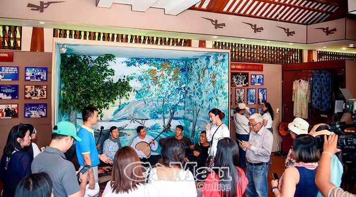 Du khách nghe thuyết minh về Khu Lưu niệm Nghệ thuật đờn ca tài tử Nam Bộ và Nhạc sĩ Cao Văn Lầu.