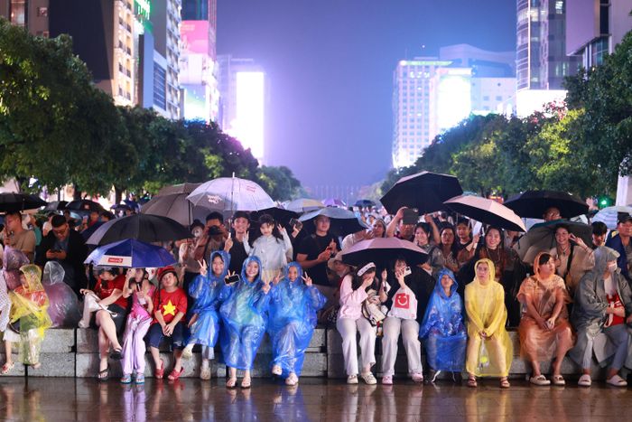 Bất chấp thời tiết không thuận lợi, người dân thành phố vẫn đội mưa, sẵn sàng cho những màn trình diễn nghệ thuật đặc sắc