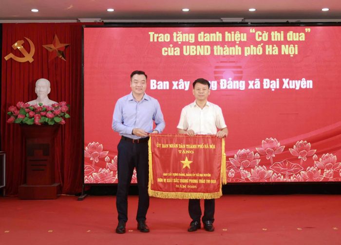 Trao tặng Cờ thi đua của UBND thành phố Hà Nội cho Ban Xây dựng Đảng xã Đại Xuyên. Ảnh: TN