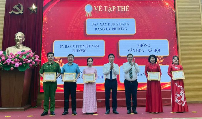 Bí thư Đảng ủy, Chủ tịch HĐND phường Ô Chợ Dừa Nguyễn Anh Quân và Phó Bí thư Đảng ủy, Chủ tịch UBND phường Lê Tuấn Định trao khen thưởng cho các tập thể. Ảnh: Võ Giang