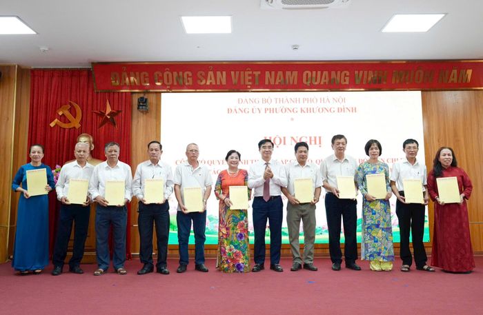 Bí thư Đảng ủy, Chủ tịch HĐND phường Khương Đình Võ Đăng Dũng trao các quyết định thành lập chi bộ, quyết định đổi tên chi bộ và công tác cán bộ sau sắp xếp tổ dân phố. Ảnh: Hồng Thái