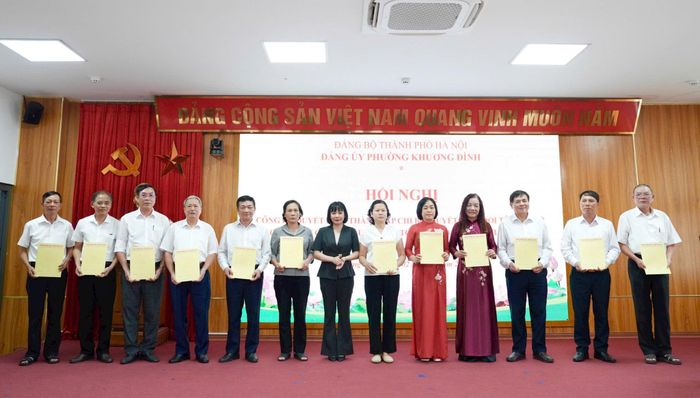 Phó Bí thư Thường trực Đảng ủy phường Khương Đình Trần Thị Nga trao các quyết định thành lập chi bộ, quyết định đổi tên chi bộ và công tác cán bộ sau sắp xếp tổ dân phố. Ảnh: Hồng Thái