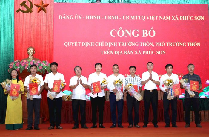 Phó Bí thư Đảng ủy, Chủ tịch UBND xã Phúc Sơn Trần Xuân Hải và Phó Chủ tịch HĐND xã Phúc Sơn Vũ Văn Chuyên trao quyết định và chúc mừng tân Trưởng thôn trên địa bàn. Ảnh: Kim Nhuệ