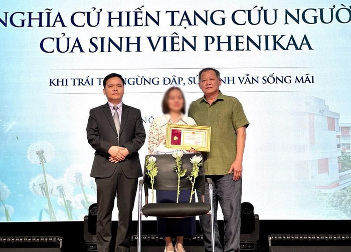 Lãnh đạo Trường Y - Dược Phenikaa và Bệnh viện Hữu nghị Việt Đức cùng thực hiện nghi thức trao lại chiếc áo blouse trắng và Bằng khen của Bộ Y tế cho gia đình nam sinh