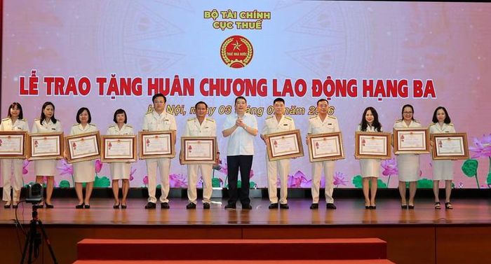 Thừa ủy quyền của Chủ tịch nước, Thứ trưởng Bộ Tài chính Cao Anh Tuấn trao Huân chương Lao động cho các tập thể, cá nhân - Ảnh: VGP