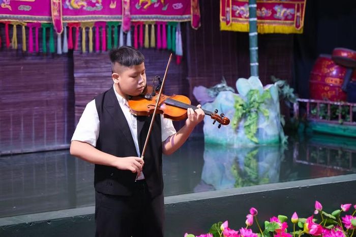 Cháu Bùi Bảo Minh, chuyên ngành Violin năm 3 khoa dây, Học viện Âm nhạc Quốc gia Việt Nam tự tin biểu diễn trên sân khấu với tiết mục “Beethoven Virus”.